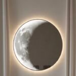 Decorative full moon mirror with textured lunar surface mounted on living room wall